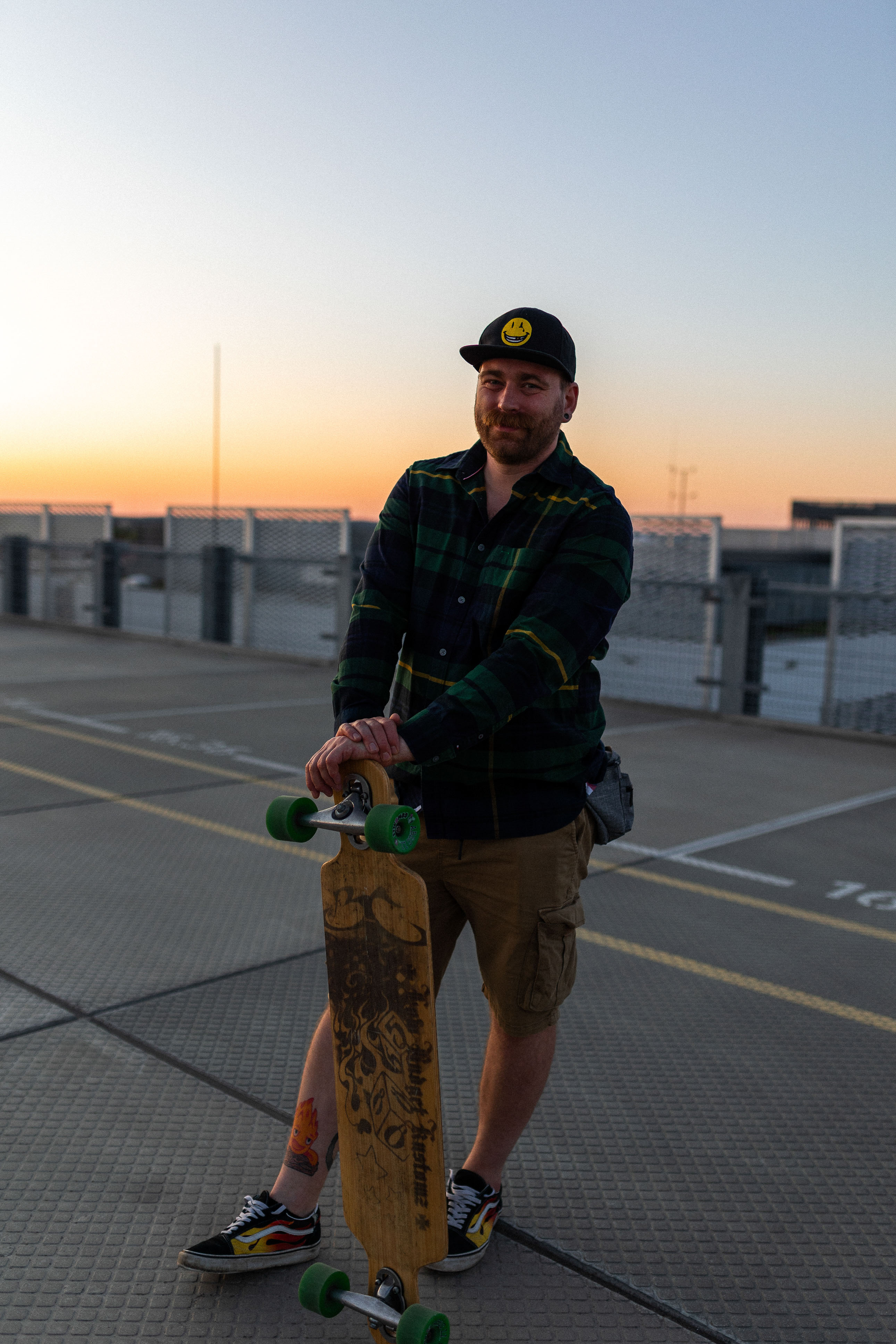 Portraitshooting eines Mannes mit Skateboard auf einem Parkhausdeck bei Sonnenuntergang in Erlangen